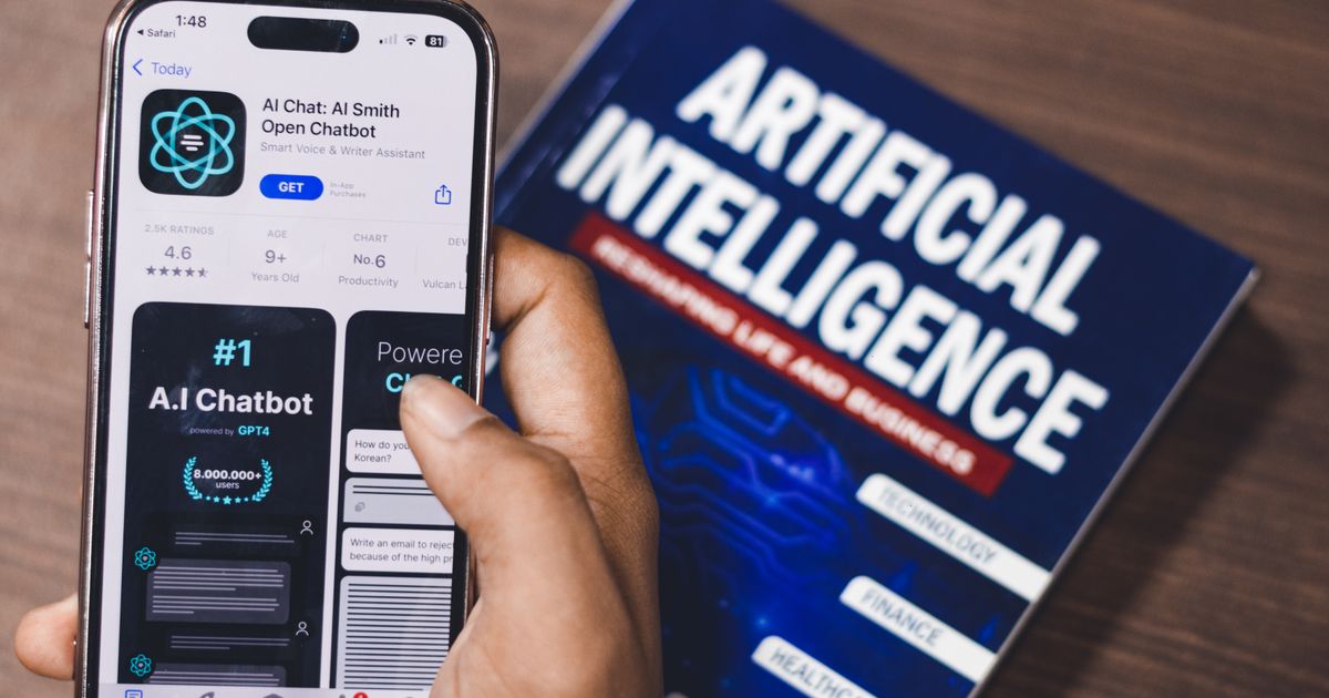 Smartphone showing an AI chatbot app next to a book titled Artificial Intelligence, representing the 2026 AI skills and job boom