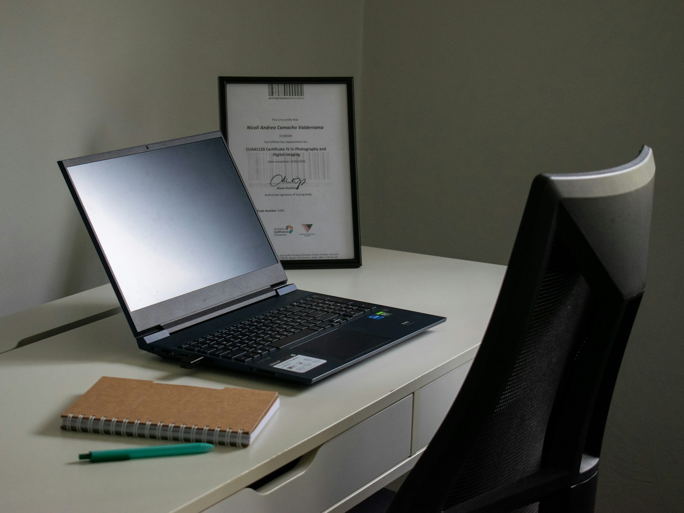 Laptop, notebook, and pen on a desk for comparing Azure certification exam options