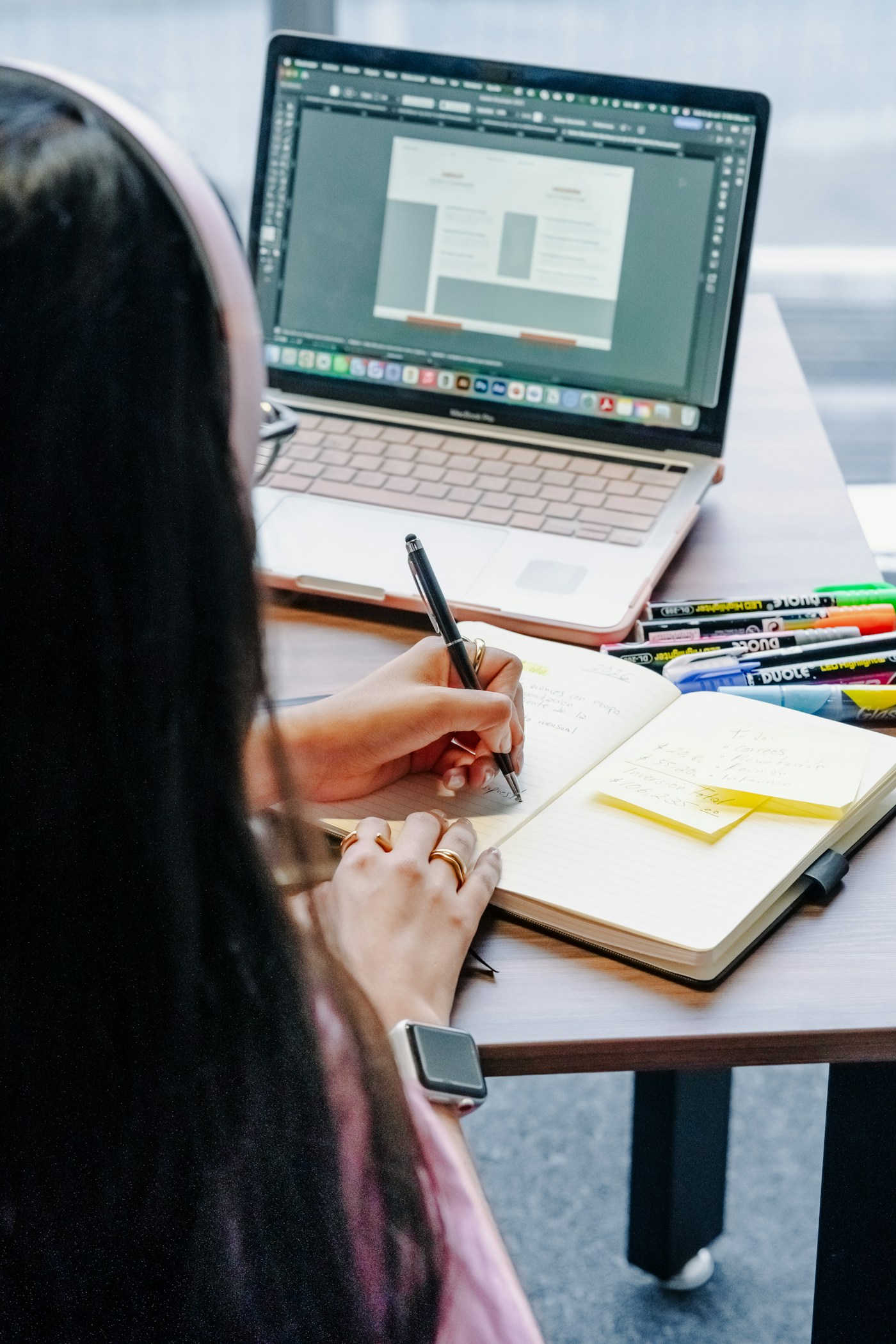 Person working through certification study notes beside a laptop