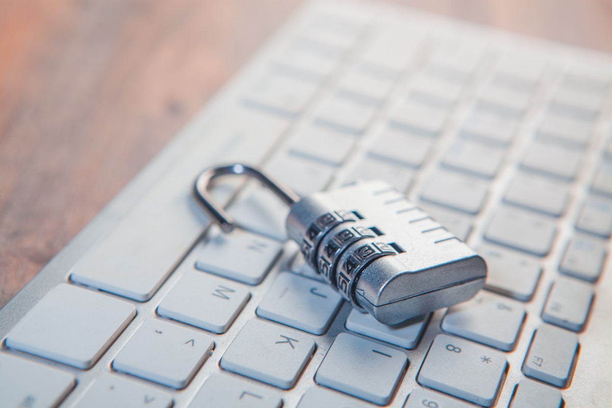Combination padlock resting on a computer keyboard, representing the Security+ SY0-701 versus SY0-801 exam decision